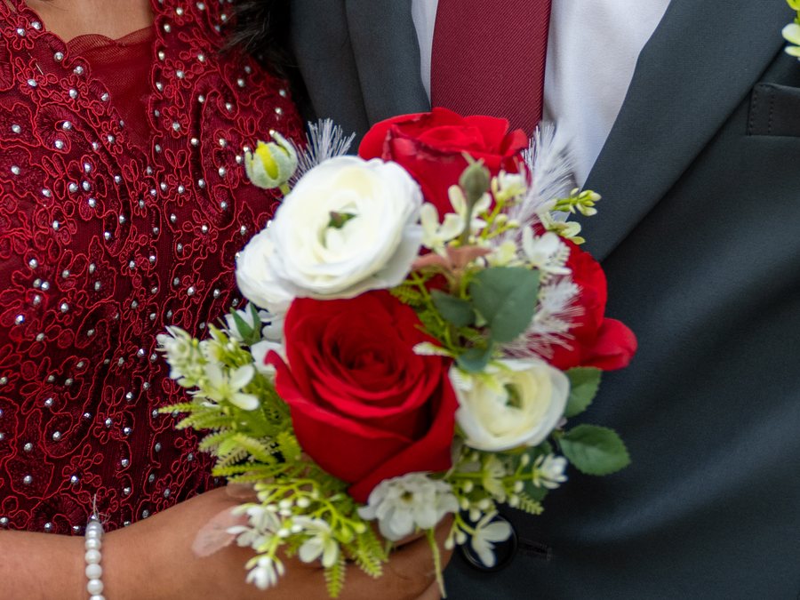 Small hand-tied bouquet of red roses and white ranunculus