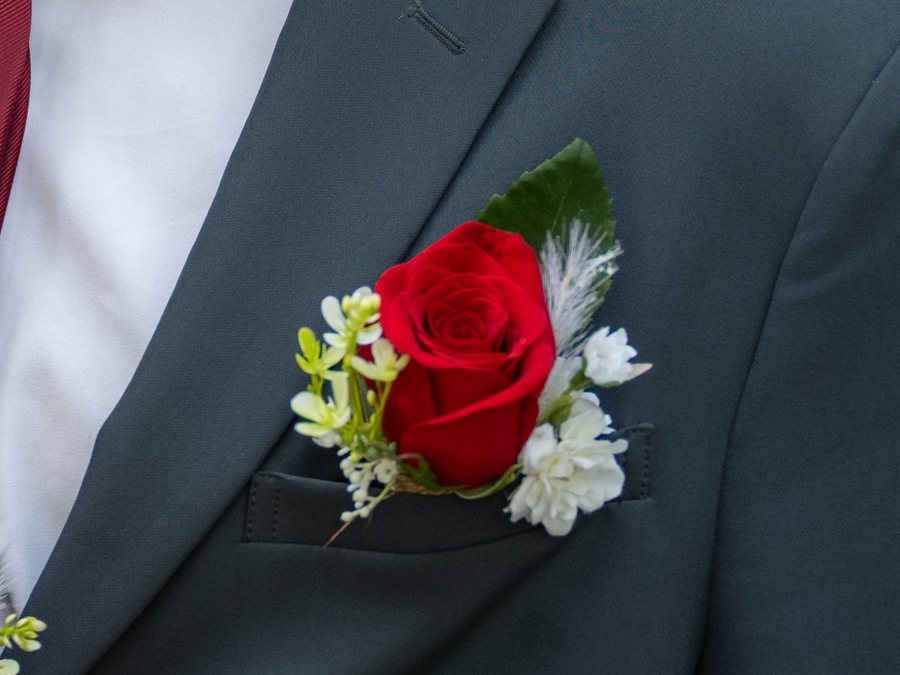 Red rose boutonnière on a grey suit lapel